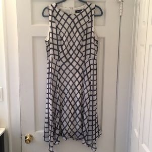 White sleeveless dress with blue cross-hatch pattern. Handkerchief hemline.